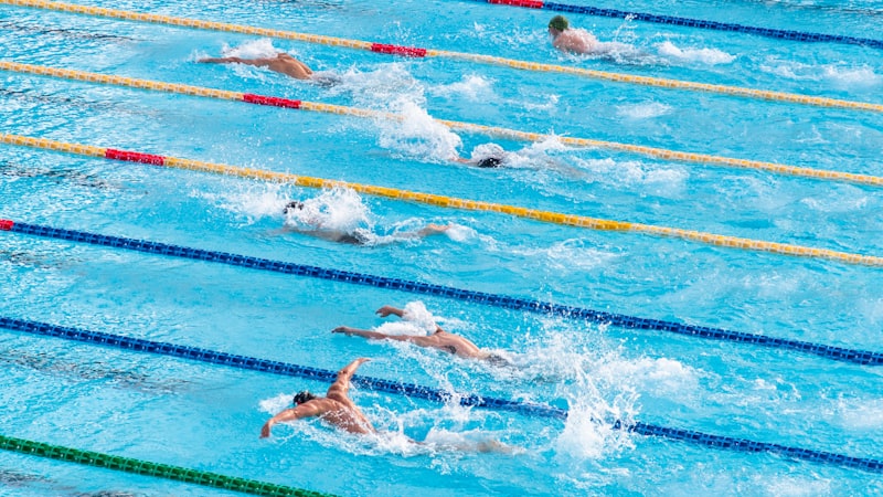 世界泳联锦标赛游泳比赛，运动员在蔚蓝泳池中奋力划水，水花四溅