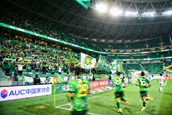北京国安队在新工体比赛，绿色看台形成壮观的主场氛围