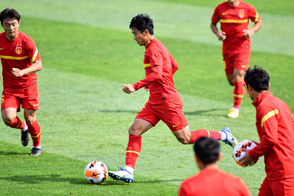 山东泰山足球队赛前训练，球员在绿茵场上进行传接球练习