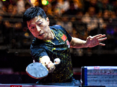 中国乒乓球运动员马龙在比赛中反手拧拉瞬间，表情专注坚定