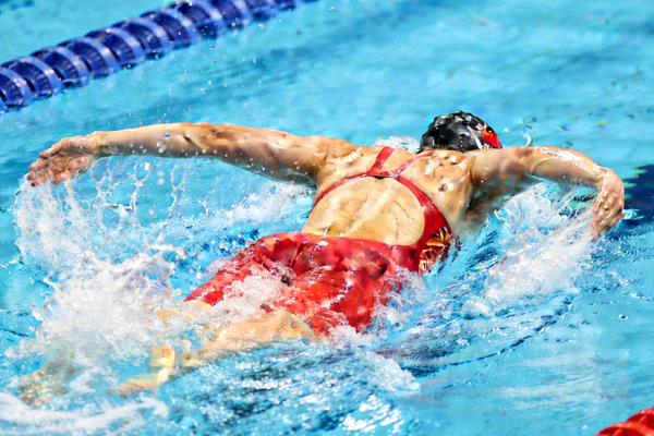 中国游泳运动员张雨霏在蝶泳比赛中奋力划水，水花四溅